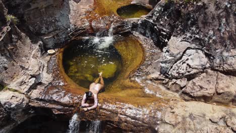 High-angle-view-of-woman-in-clear-waterfall-pool,-Posas-de-Santiago