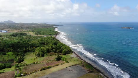 The-abandoned-pearls-airport-in-grenada-with-coastline-and-lush-terrain,-daylight,-aerial-view