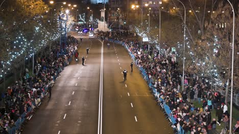 Police-officers-secure-the-road-ahead-for-the-Three-Wise-Men-festival,-also-known-as-the-Three-Kings-Parade,-a-family-spectacle-featuring-floats-with-wise-men,-dancers,-musicians,-and-candy-giveaways