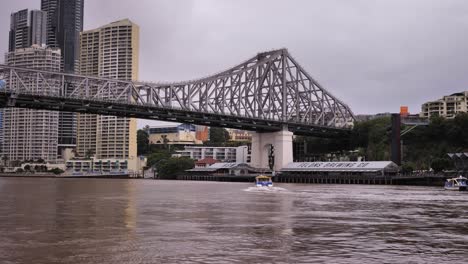 View-of-river-ferry,-Story-Bridge,-Howard-Smith-Wharves-and-high-rise-buildings-from-New-Farm-River-Walk