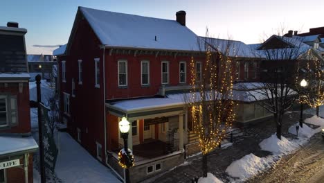 Colonial-two-story-house-on-main-street-of-snow-covered-American-town-during-Christmas-time