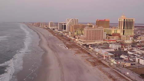 Drone-Volando-Hacia-Atrás-A-Lo-Largo-De-La-Costa-Atlántica-De-La-Ciudad-Mostrando-Casinos