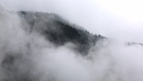 Fast-moving-clouds-in-front-of-a-forest-hill