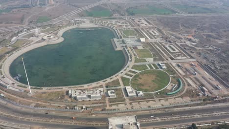 rajkot-atal-lake-drone-view-The-drone-camera-is-moving-forward-where-the-big-garden-and-Ashoka-Chakra-are-visible,-Rajkot-New-Race-Course,-Atal-Sarovar