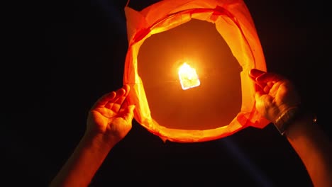 Person-launching-sky-paper-lantern,-Porto's-São-João-night