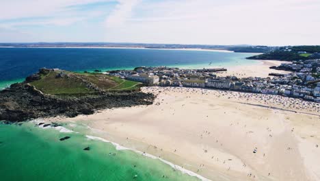 Porthmeor-Beach-in-St-Ives,-Cornwall-with-Aerial-Views-over-the-Cornish-Town-on-a-Summers-Day