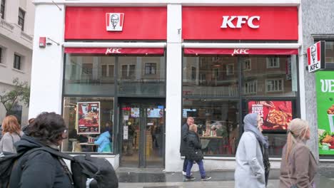 Kunden-Verlassen-Das-Kentucky-Fried-Chicken-Restaurant,-Die-Amerikanische-Fast-Casual-Hähnchenkette,-In-Spanien