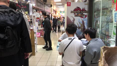 Teenagers-play-card-games-in-a-shopping-mall-in-Tai-Po,-Hong-Kong