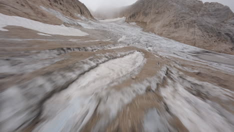 Drone-flying-at-low-altitude-over-Marmolada-Glacier,-Trentino-in-Italy