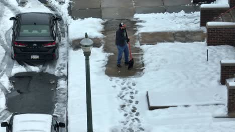 Aerial-view-of-a-man-shoveling-a-sidewalk