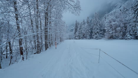 POV-walk-through-the-heavy-snow-in-the-winter-valley-of-Lauterbrunnen,-Switzerland