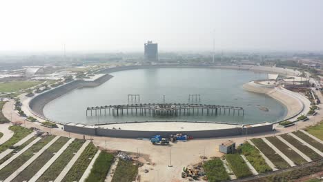 rajkot-atal-lake-drone-view-drone-camera-moving-upwards-where-a-big-lake-is-visible-and-many-guards-around-and-a-big-clock-is-also-visible,-Rajkot-New-Race-Course,-Atal-Sarovar