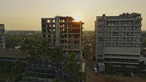 Negombo-Sri-Lanka-Aerial-v5-cinematic-drone-flyby-seaside-hotels-capturing-sandy-beach,-coastal-residential-areas-and-beautiful-golden-sun-rising-on-the-sky---Shot-with-Mavic-3-Cine---April-2023