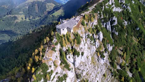 Rustikale-Hütte-Inmitten-Leuchtenden-Herbstlaubs,-Rauch-Kräuselt-Sich-Aus-Dem-Schornstein-In-Die-Frische-Morgenluft