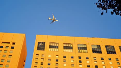 Editorial-footage-showing-typical-upward-looking-view-of-aircraft-flying-over-a-section-of-Tokyo,-Japan