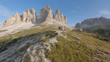 Zwei-Freunde-Bewundern-Die-Landschaft-Der-Dolomiten,-Luftbild-FPV-Vorbeiflug