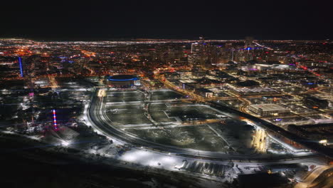 Denver-downtown-i25-highway-traffic-aerial-drone-snowy-winter-evening-dark-night-city-lights-landscape-Colorado-cinematic-anamorphic-Elitch-Gardens-Ball-Arena-circle-left-movement