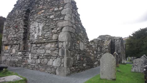 An-establishing-pan-shot-of-the-stone-ruins-of-St-Matthews-Church-at-Aughadown-graveyard-in-Cork,-Ireland