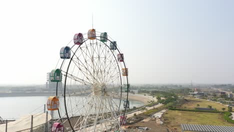 Rajkot-Atal-See:-Drohnenansicht.-Die-Drohnenkamera-Geht-Zur-Seite-Und-Man-Sieht-Ein-Großes-Riesenrad.-In-Der-Umgebung-Sind-Auch-Viele-Gärten-Zu-Sehen,-Die-Neue-Rennstrecke-Von-Rajkot,-Atal-Sarovar