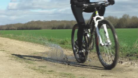 A-mountain-biker-cycling-his-bike-under-a-clear-sky-with-forest-at-background-in-France