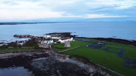 An-aerial-drone-shot-panning-around-to-reveal-the-beautiful-Irish-Sea-coastline-at-Skerries-Beach-on-an-overcast-evening-in-Dublin,-Ireland