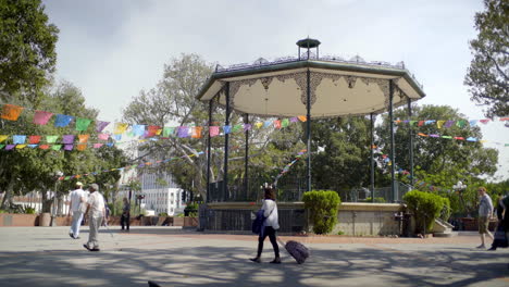 Im-Pueblo-De-Los-Angeles-Plaza,-Kalifornien,-USA,-ähnelt-Einem-Mexikanischen-Dorf-Mit-Banderitas,-Flanierenden-Menschen-Und-Tauben-Unter-Baumsilhouetten