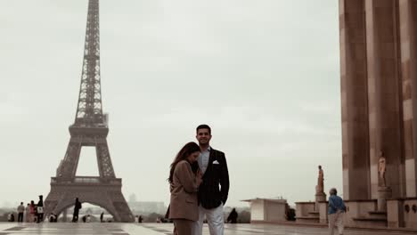 Elegantes,-Schönes-Paar-Kuschelt-Sanft-Auf-Dem-Palais-De-Chaillot-Vor-Dem-Berühmten-Eiffelturm-In-Paris,-Frankreich---Weite-Aussicht-Mit-Einigen-Touristen-In-Der-Nähe