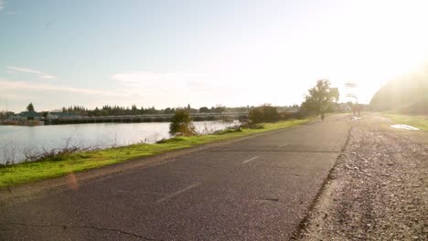 Ciclista-En-El-Camino-Del-Río-Al-Atardecer