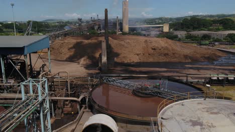 Drone-over-the-machinery-of-a-paper-and-tissue-wadding-mill-to-reveal-the-bagasse-tailings-pile