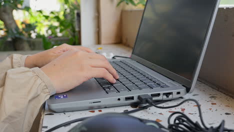 Girl's-Hand-Busy-Working-on-a-Dell-Laptop-in-a-Natural-Setting