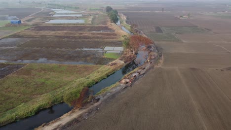 Drone-video-of-soil-road,-rivers-and-canals-in-East-Asia-villages