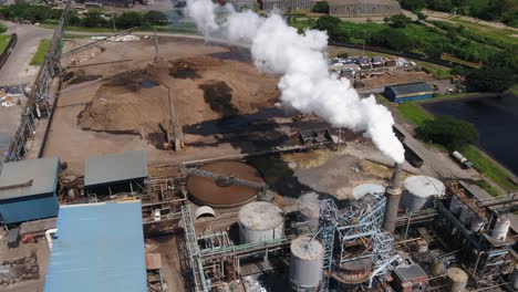 Drone-Alto-Sobre-Una-Fábrica-De-Papel-Y-Tejidos-En-Sudáfrica-Con-Contaminación-Del-Aire-Visible-Y-Relaves-De-Bagazo