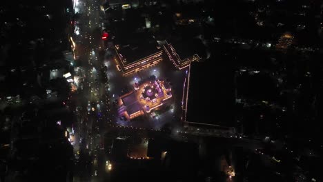 Rajkot-aerial-drone-view-drone-camera-has-a-big-temple-with-lights-and-lots-of-vehicles-driving-on-the-road-around