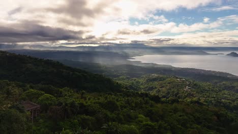 Drohnenaufnahme-über-Der-Idyllischen-Berglandschaft-Der-Philippinen-Und-Dem-Taal-See-Im-Hintergrund-Bei-Sonnenuntergang