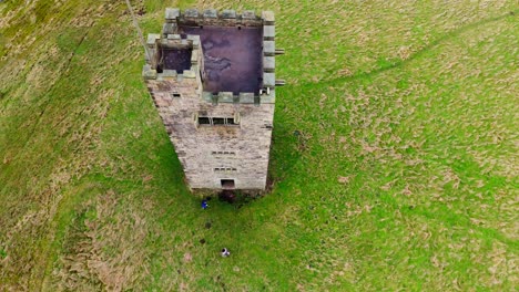 Altes-Verfallenes-Schloss,-Denkmal,-Stillgelegter-Steinturm,-Mit-Leuten,-Die-Herumlaufen-Und-Eine-Drohne-Fliegen