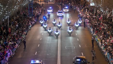 Police-officers-ride-motorcycles-and-cars-as-people-celebrate-the-Three-Wise-Men,-also-known-as-the-Three-Kings-Parade