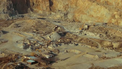 Stone-quarry-aerial-close-up-shot-showing-winding-roads-and-heavy-machinery