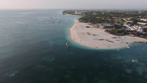 Tourists-boats-sails-near-the-awesome-beach-of-Zanzibar,-summer-concept,-carefree-holiday,-Africa,-Tanzania