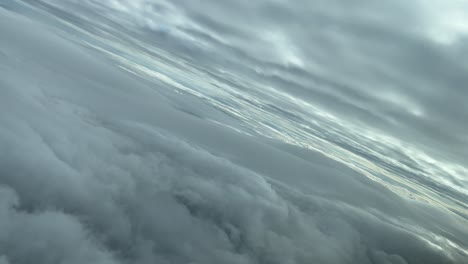 POV-Luftaufnahme-Einer-Wolkenlandschaft-Aus-Einer-Flugzeugkabine,-Die-über-Wolkenschichten-Fliegt-Und-Nach-Links-Abbiegt