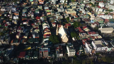 Drone-circling-the-sunlit-Church-of-Christ,-golden-hour-in-Manila,-Philippines