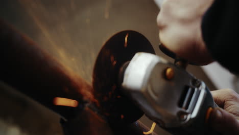 Close-up-of-metal-worker-cutting-old-tubing-on-construction-site