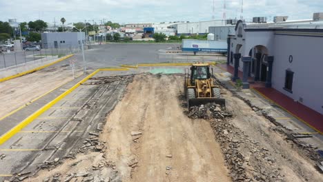 Backhoe-demolishing-a-parking-lot