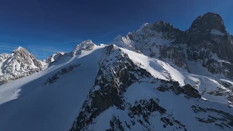 Atemberaubende-Luftaufnahmen-Von-Majestätischen,-Schneebedeckten-Bergen,-Die-Im-Glanz-Eines-Klaren,-Sonnigen-Himmels-Baden