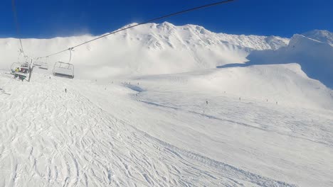 POV-Sesselliftaufstieg:-Sonniger-Blick-Auf-Skifahrer-Bei-Der-Abfahrt