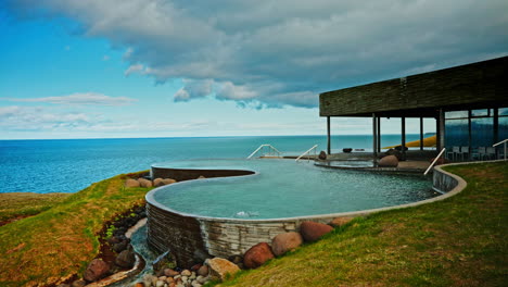 Outdoor-Icelandic-thermal-spa-with-breathtaking-view-of-the-nordic-ocean-and-majestic-snowy-mountains-the-distance