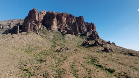 Low-parallax-around-Superstition-Mountains-dotted-with-green-shrubs-on-sunny-bright-day