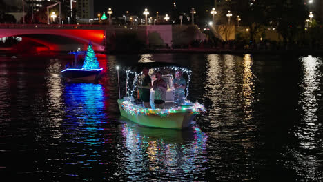 People-On-Lighted-Boat-Navigating-Along-River-By-Night,-Christmas-Boat-Parade-Tampa-Florida