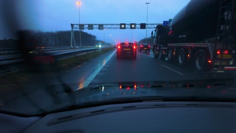 Car-pov-through-window-with-rain-and-wiper-of-traffic-jam-with-cars-and-trucks-standstill