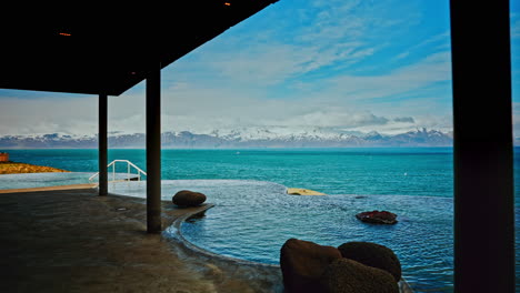 Isländisches-Thermalbad-Im-Freien-Mit-Atemberaubender-Aussicht-Auf-Das-Nordmeer-Und-Die-Majestätischen-Schneebedeckten-Berge-In-Der-Ferne