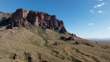 Superstition-Mountains-stand-tall-above-scrubland-desert-with-lush-green-vegetation-in-ravines